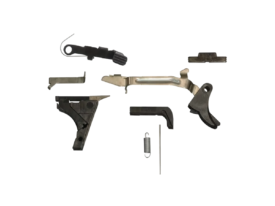 G80 Lower Parts Kit laid out: trigger with trigger bar, trigger housing with ejector, connector, slide lock, slide stop release, magazine release and springs