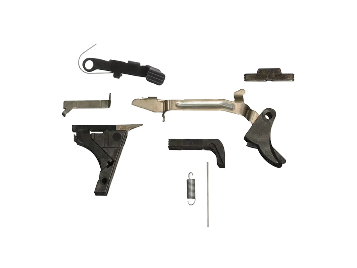 G80 Lower Parts Kit laid out: trigger with trigger bar, trigger housing with ejector, connector, slide lock, slide stop release, magazine release and springs